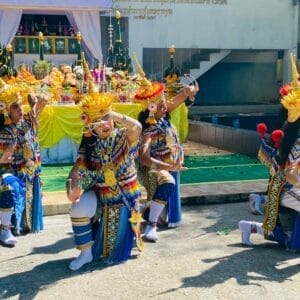คณะนักแสดงมโนราห์สวมชุดเต็มยศ กำลังร่ายรำในพิธีไหว้ครูหรือพิธีบวงสรวงทางภาคใต้ของไทย